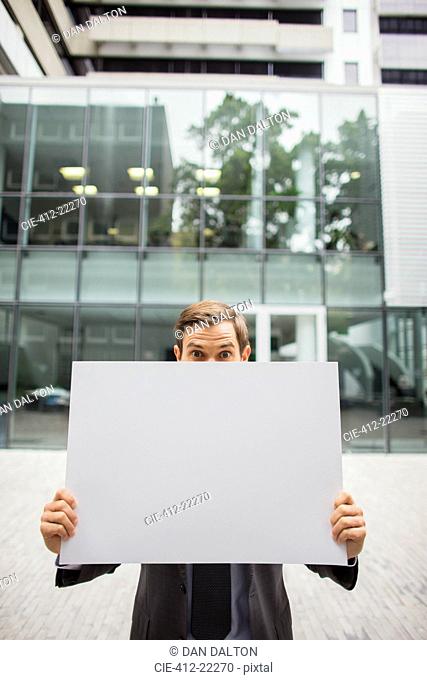 Businessman holding cardboard outside of office building