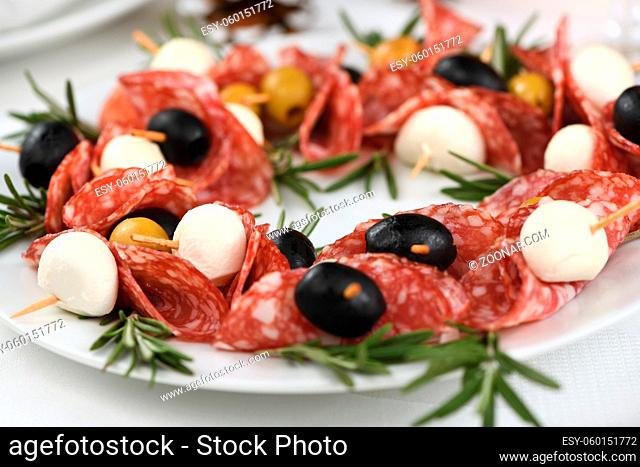 Christmas wreath - antipasto. Salami canapes with olives, baby mozzarella