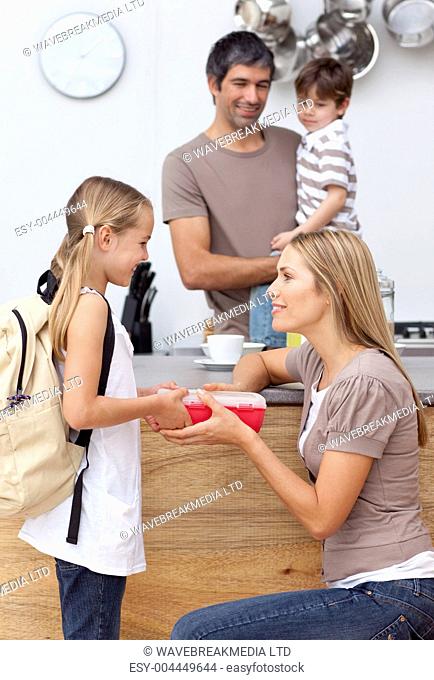 Mother giving her daughter the school lunch
