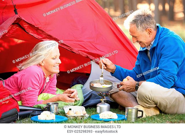 Senior Couple Cooking Breakfast On Camping Holiday