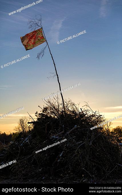 16 April 2022, Brandenburg, Cottbus: The sun sets behind an Easter fire that is not yet burning. The comrades of the volunteer fire department of the Cottbus...