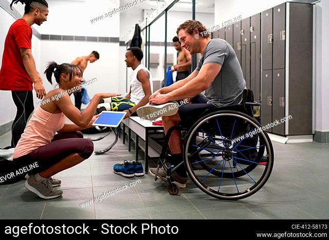 Coach and wheelchair athlete talking in locker room
