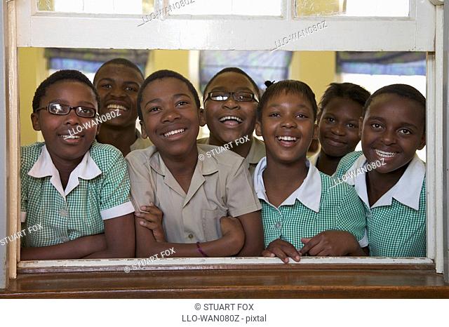 Group shot of schoolchildren looking out of their classroom window, KwaZulu Natal Province, South Africa