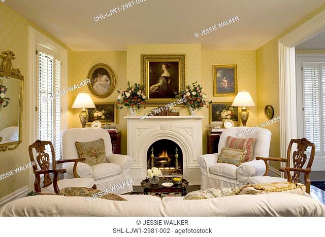 LIVING ROOMS, Romanesque style fireplace, romantic English style, white slipcovers, yellow walls, portrait paintings and floral still life