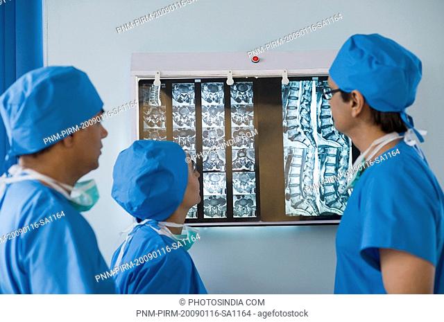 Three surgeons examining an x-ray report, Gurgaon, Haryana, India