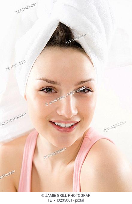 Studio portrait of smiling young woman with towel turban