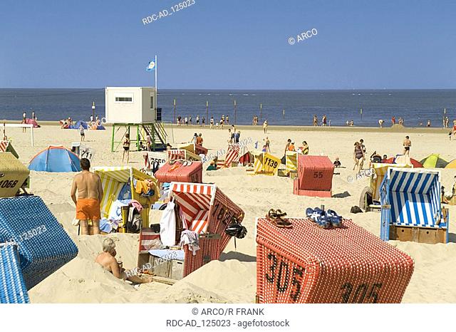 Wicker beach chairs vacationists and lifeguard station at beach Island Langeoog Lower Saxony Germany