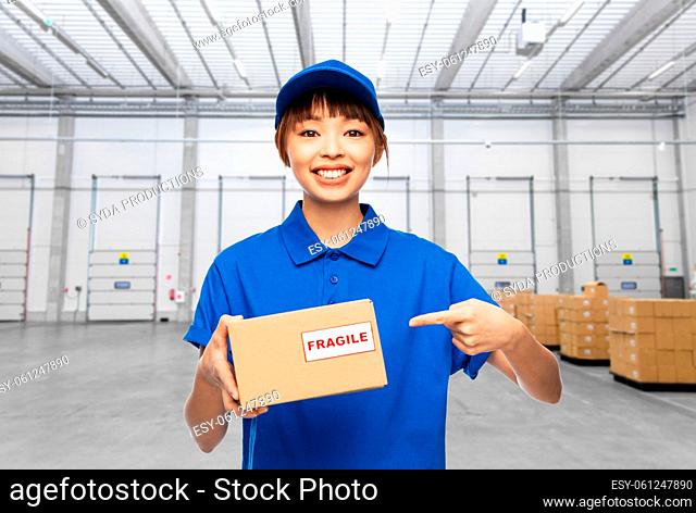 happy delivery woman with parcel at warehouse