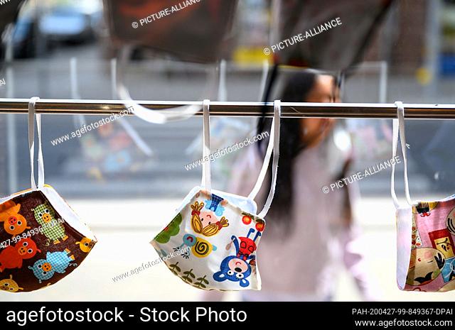 27 April 2020, Baden-Wuerttemberg, Stuttgart: Face masks with patterns for children hang in a store. In order to slow down the spread of the coronavirus