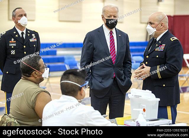 US President Joe Biden is is escorted by the Director of Walter Reed National Military Medical Center Colonel Andrew Barr (R) on a tour of a COVID-19 v...