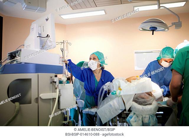 Reportage in the orthopedic surgery service in LÚman hospital, Thonon, France. Operating theatre. The anaesthetist checks the patient's vital signs during the...