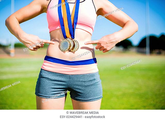 Mid section of female athlete with gold medals around her neck
