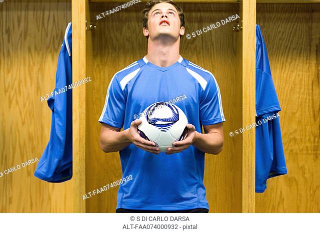 Young soccer player holding soccer ball