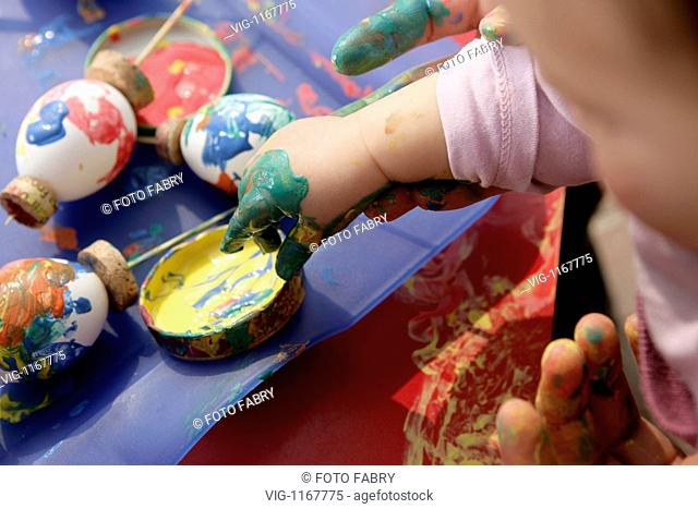 GERMANY, GAGGENAU, 03.04.2009, Child is playing with Fingercolours in a Paint Pot, on the table are Easter Egs - Gaggenau, Baden-Württemb, GERMANY, 03/04/2009