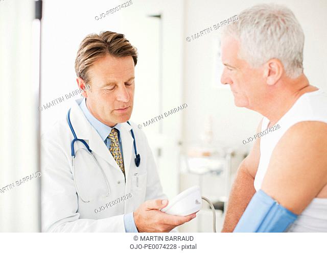 Doctor taking patient’s blood pressure in doctor’s office