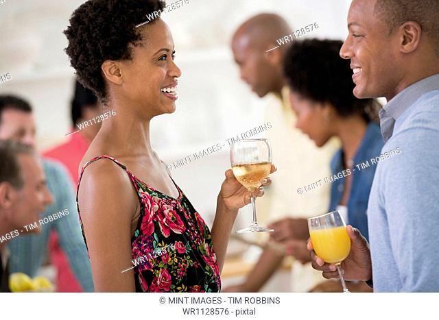 A networking office party or informal event. A man and woman, with a crowd around them