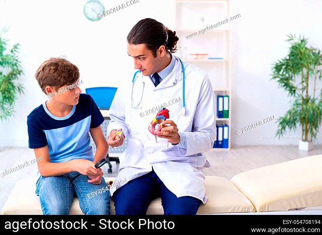 The young male doctor examining boy in the clinic