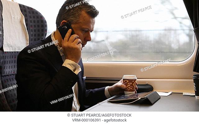 Businessman working on a tablet on a commuter train