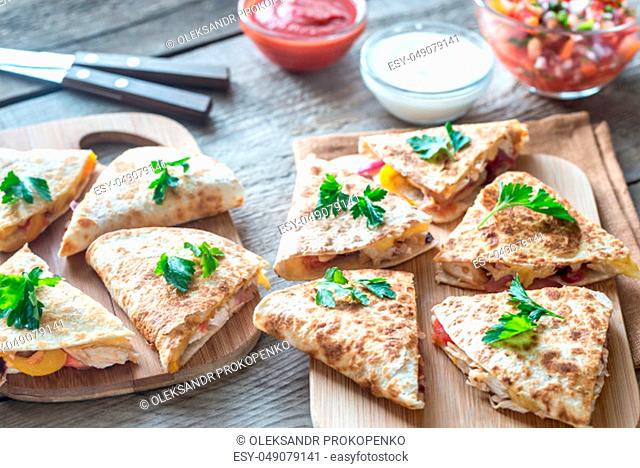 Quesadillas with cheese, spicy chicken and vegetables with different sauces