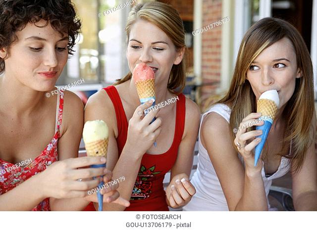 Three teenage girls eating ice creams