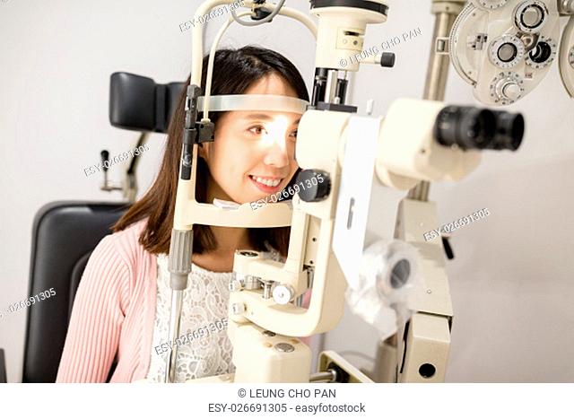 Cheerful lady having eye examination in oculist office