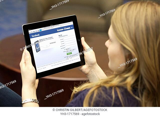 Close up picture of a young woman using Facebook social networking website on an iPad 2