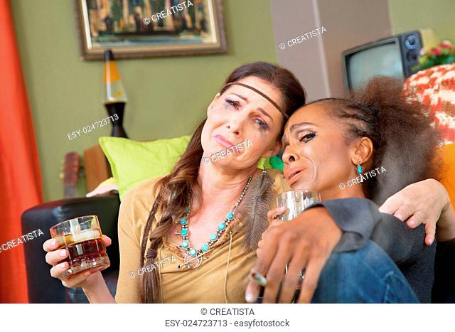 Pair of sad adult women drinking and smoking