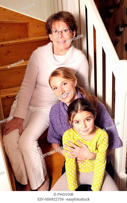 grandmother, mother, and daughter sitting on stairs