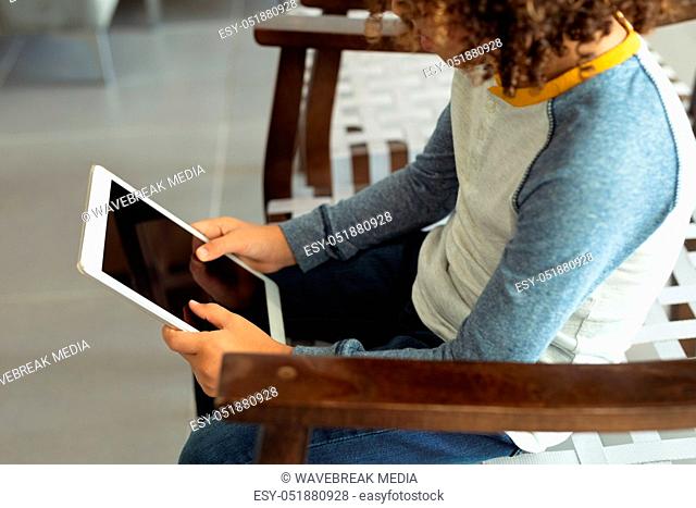 Boy using digital tablet in the lobby at hospital