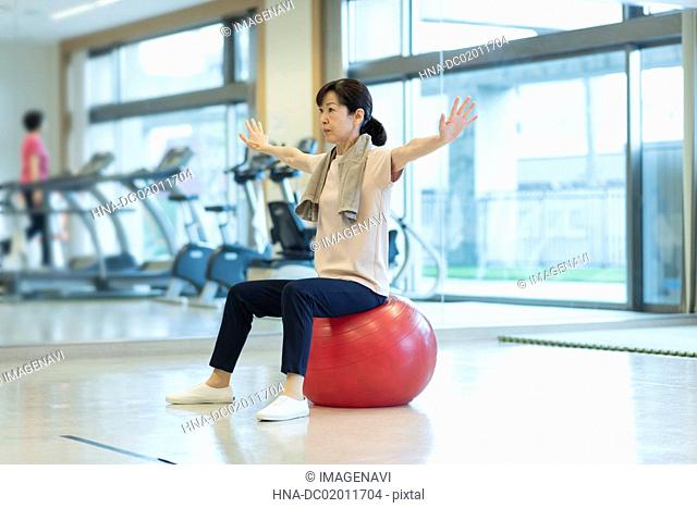Senior woman working out with balance ball