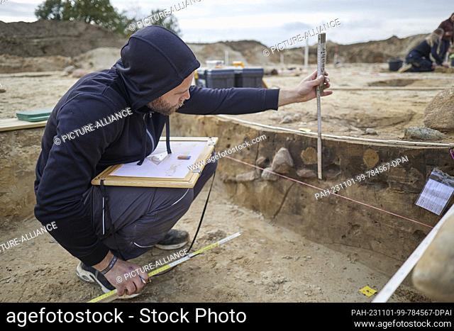 01 November 2023, Brandenburg, Seddin: Student Tim excavating an assembly hall near the burial mound of ""King Hinz."" The largest known hall of the Nordic...