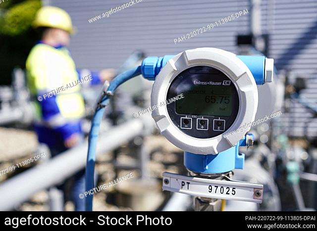 18 July 2022, Rhineland-Palatinate, Frankenthal: An employee of the company ""Enovos Storage GmbH"" stands behind a pressure gauge on the site of the gas...
