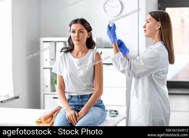 female doctor with syringe vaccinating patient