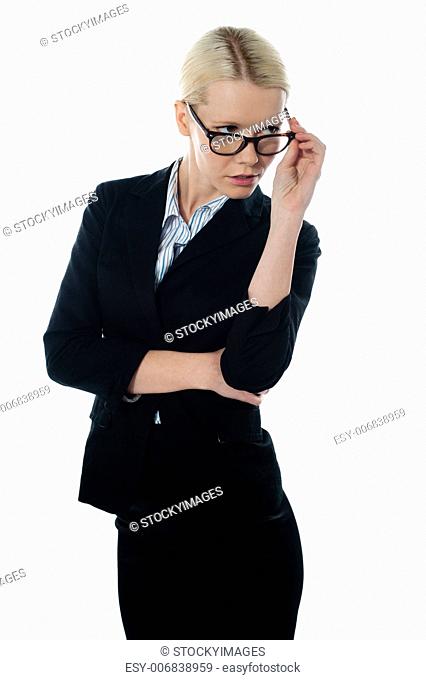 Full view of attractive businesswoman looking away from beneath her glasses