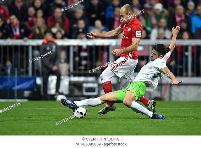 Munich's Arjen Robben (L) in action against Wolfsburg's Ricardo Rodriguez (R) and goalkeeper Diego Benaglio in the German soccer Bundesliga fixture between...