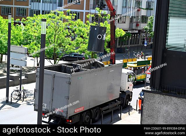 30 May 2023, North Rhine-Westphalia, Cologne: A container for waste glass is emptied into a truck Photo: Horst Galuschka/dpa/Horst Galuschka dpa
