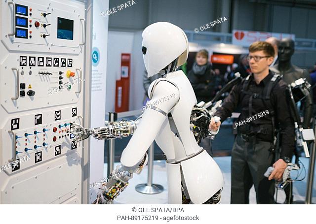 An employee of Robotic Innovation Center controls the robot AILA using an exoskeleton at the stand of the German Research Center for Artificial Intelligence...