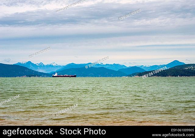 Commercial tanker ship in waters of Howe Sound with Coastal Mountains in background. Taken from Tower Beach, Vancouver, British Columbia, Canada