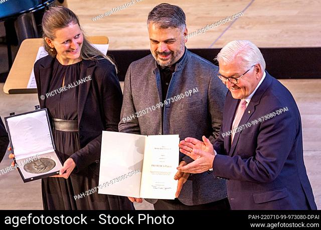 10 July 2022, Mecklenburg-Western Pomerania, Neubrandenburg: German President Frank-Walter Steinmeier (r) presents Sophia Winkelmann and Martin Riedel of the...