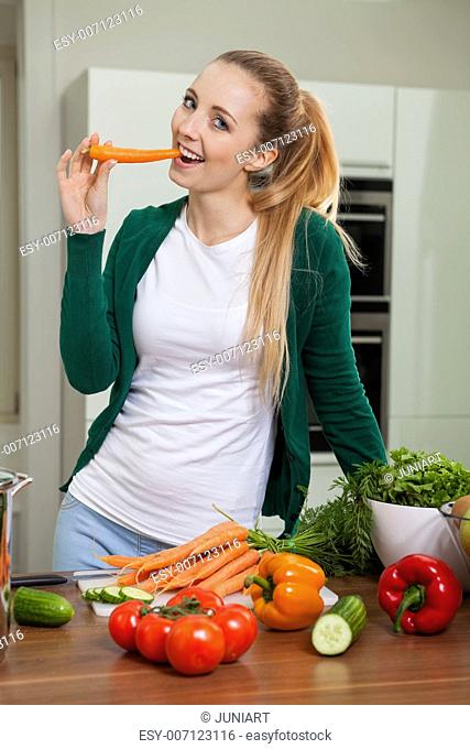 young woman cooking vegetarian food in kitchen