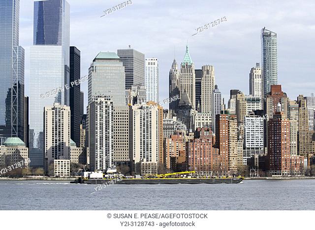 A barge on the Hudson River passes by Manhattan, New York City