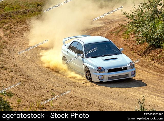 Summer sunny day. Dirt track for the rally. A car drives through a bend and makes a lot of dust 07