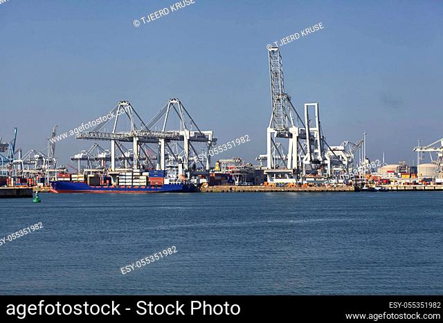 Large harbor cranes loading container ships in the port of Rotterdam in The Netherlands