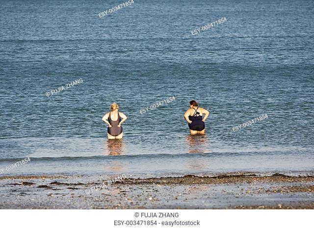 two women standing on a beach