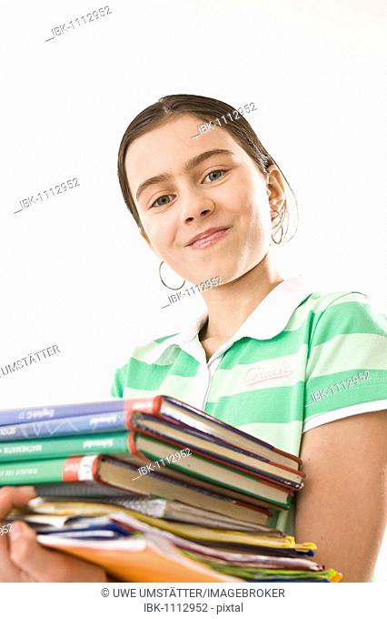 Girl carrying a pile of exercise books and school books