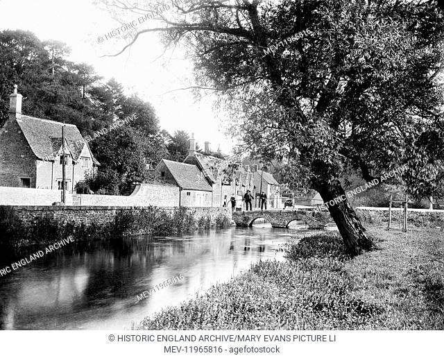 BIBURY, Gloucestershire. Looking along the river towards the stone bridge beside Arlington Row. The Cotswold village of Bibury was described as the most...