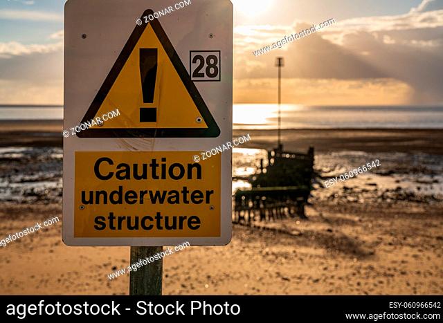 Sign: Caution, Underwater Structure, seen at the North Beach in Heacham, Norfolk, England, UK