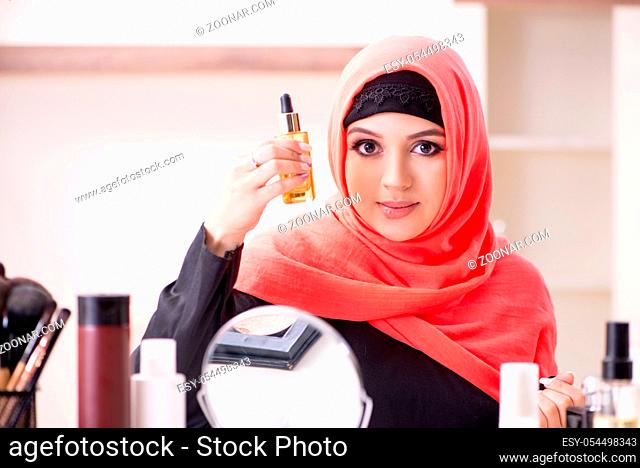 The beautiful woman in hijab applying make-up