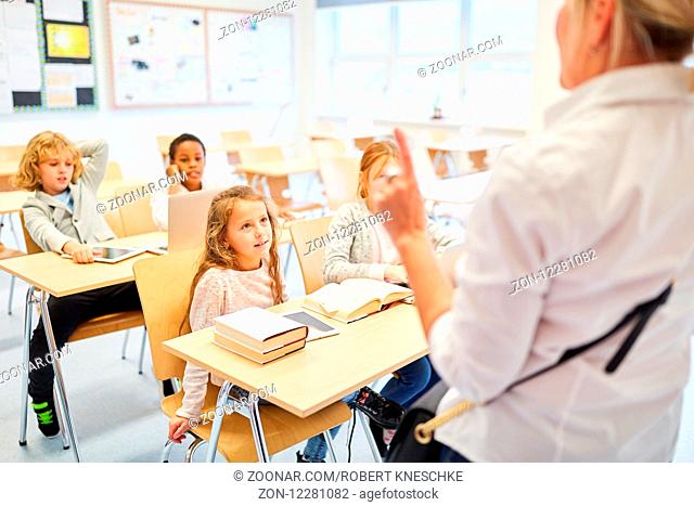 Lehrer und Schüler im Klassenzimmer beim Unterricht in einer Grundschule