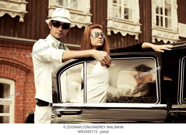 Young fashion couple at the retro car